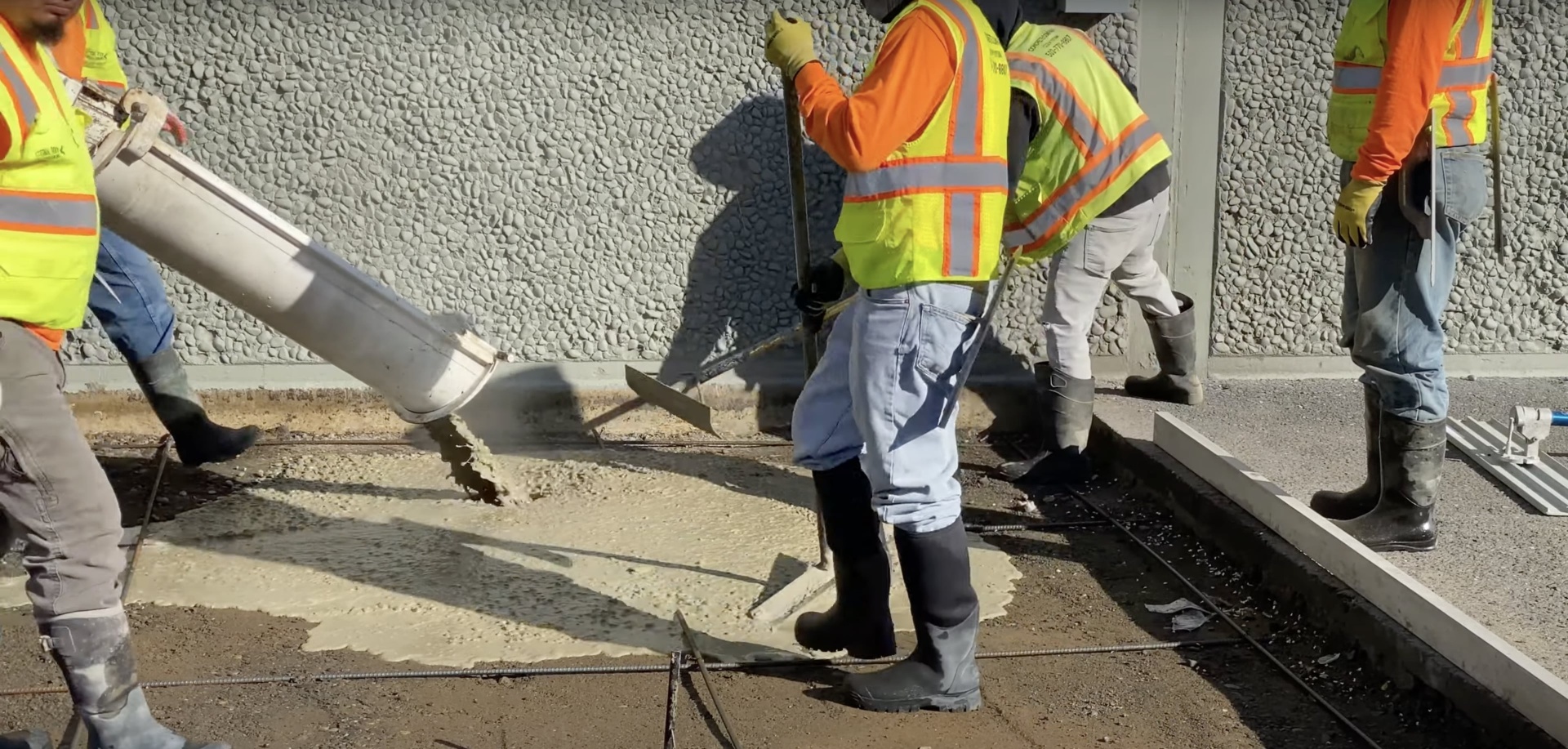 Professional concrete crew following safety protocols Construction workers in safety gear pouring concrete