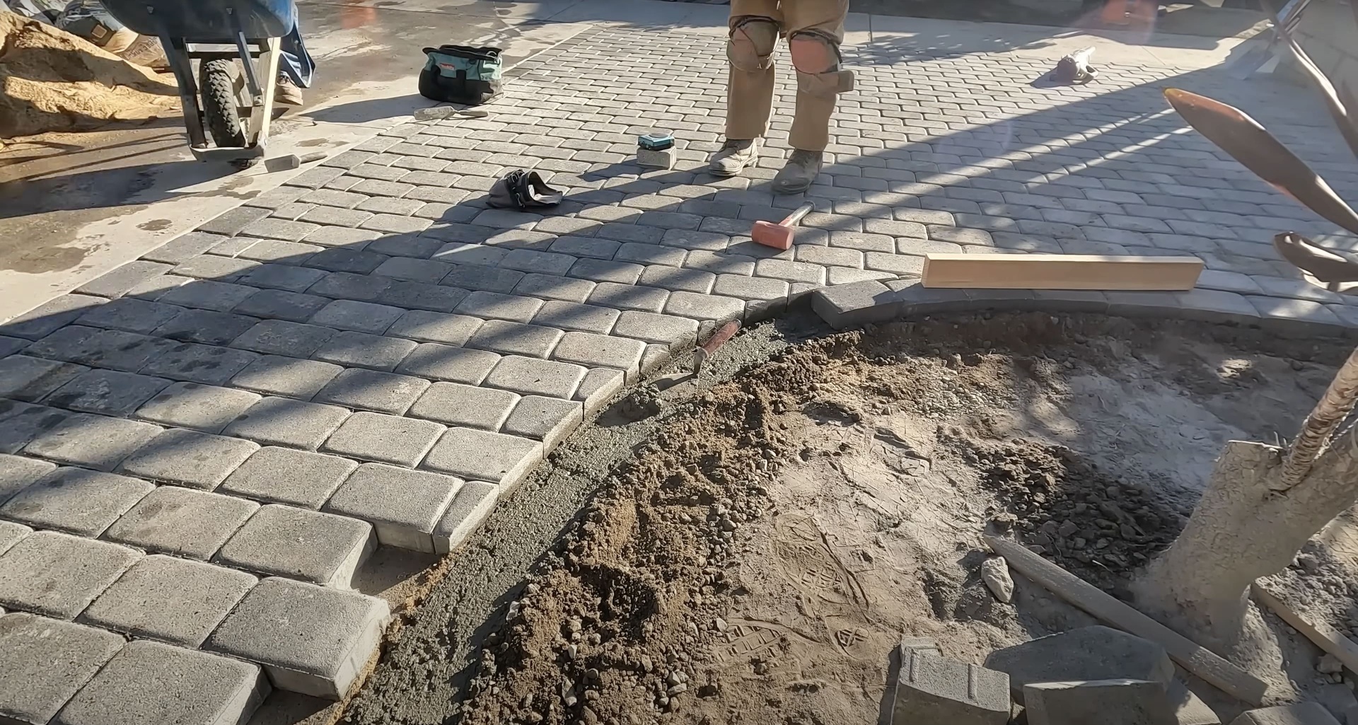 Skilled craftsmen installing concrete pavers Workers installing concrete pavers with precision