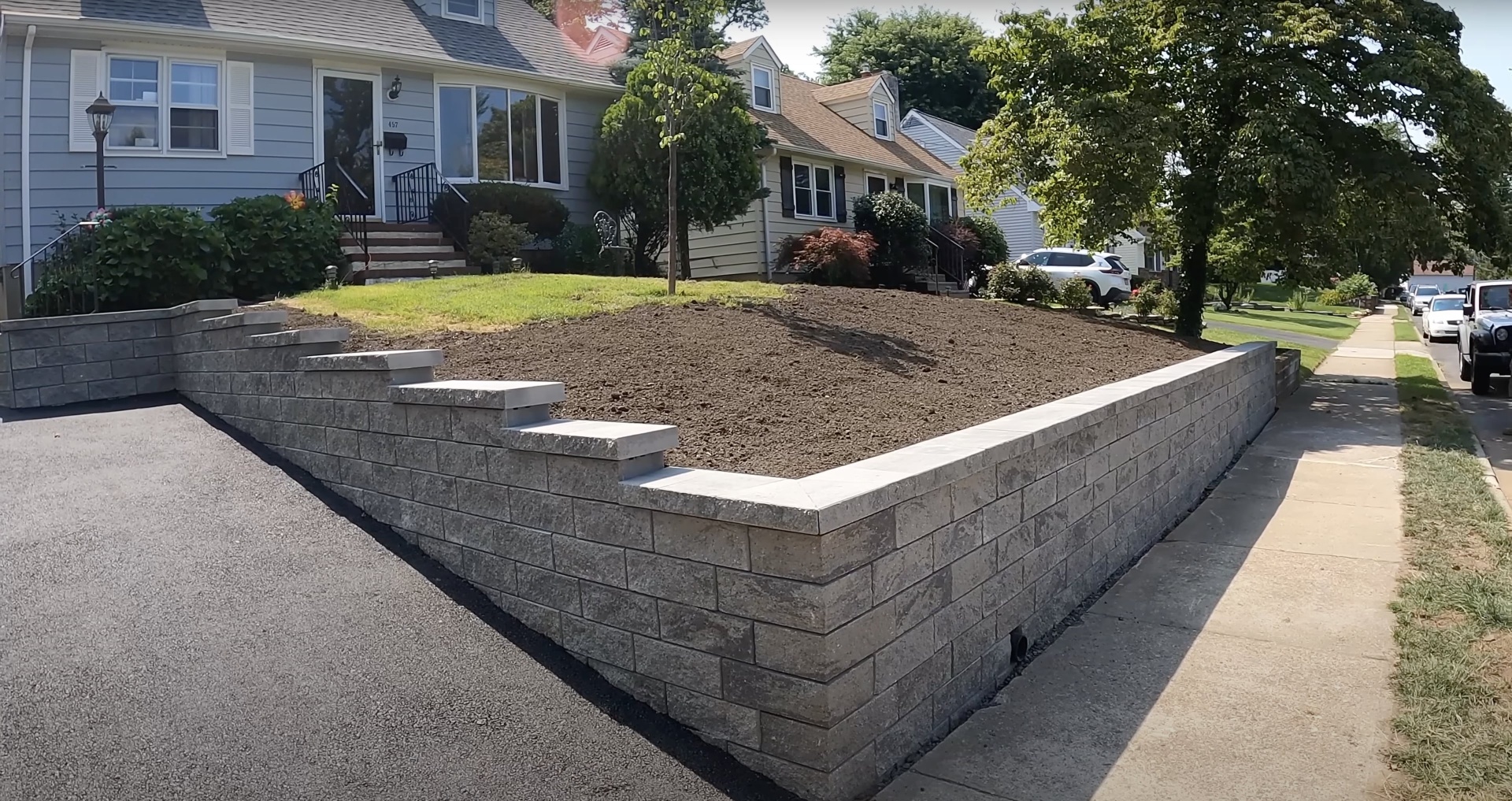 Professional concrete retaining wall construction and landscaping Completed concrete retaining wall project in residential neighborhood